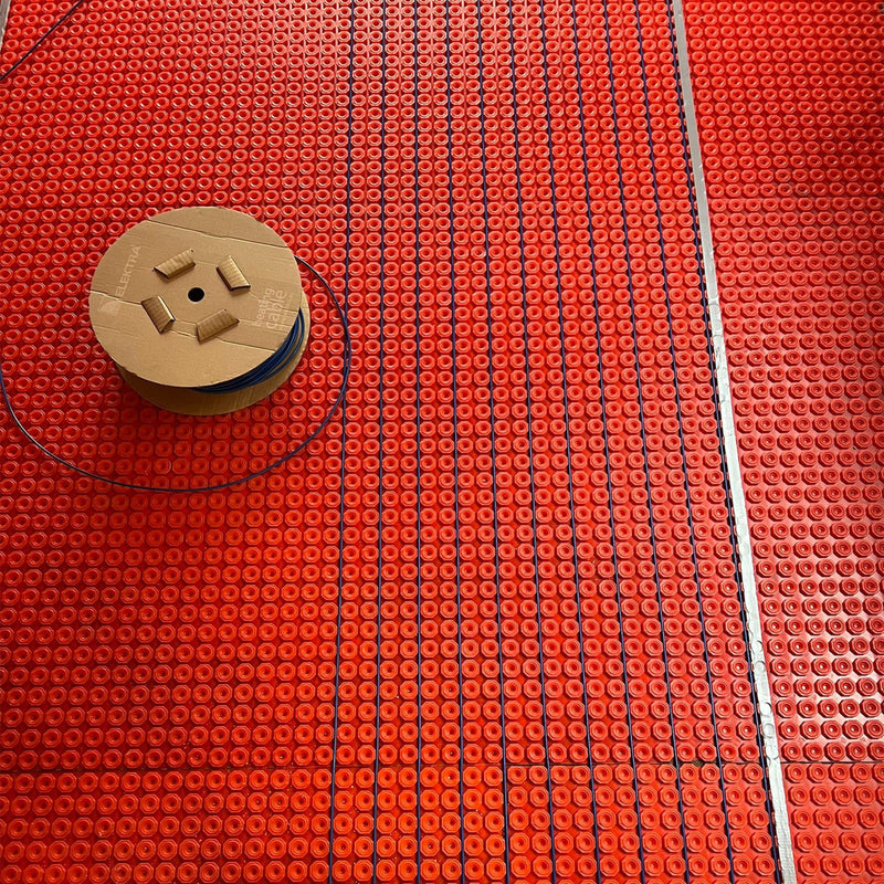 ELEKTRA DM10 heating cable being routed through the channels of a HeatBase membrane
