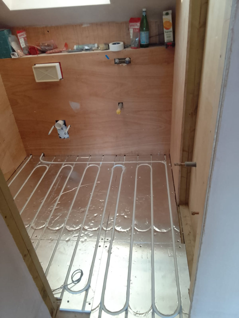 Heating pipe laid in AD-EPS400 foil-faced panels, showing return bends in a compact room