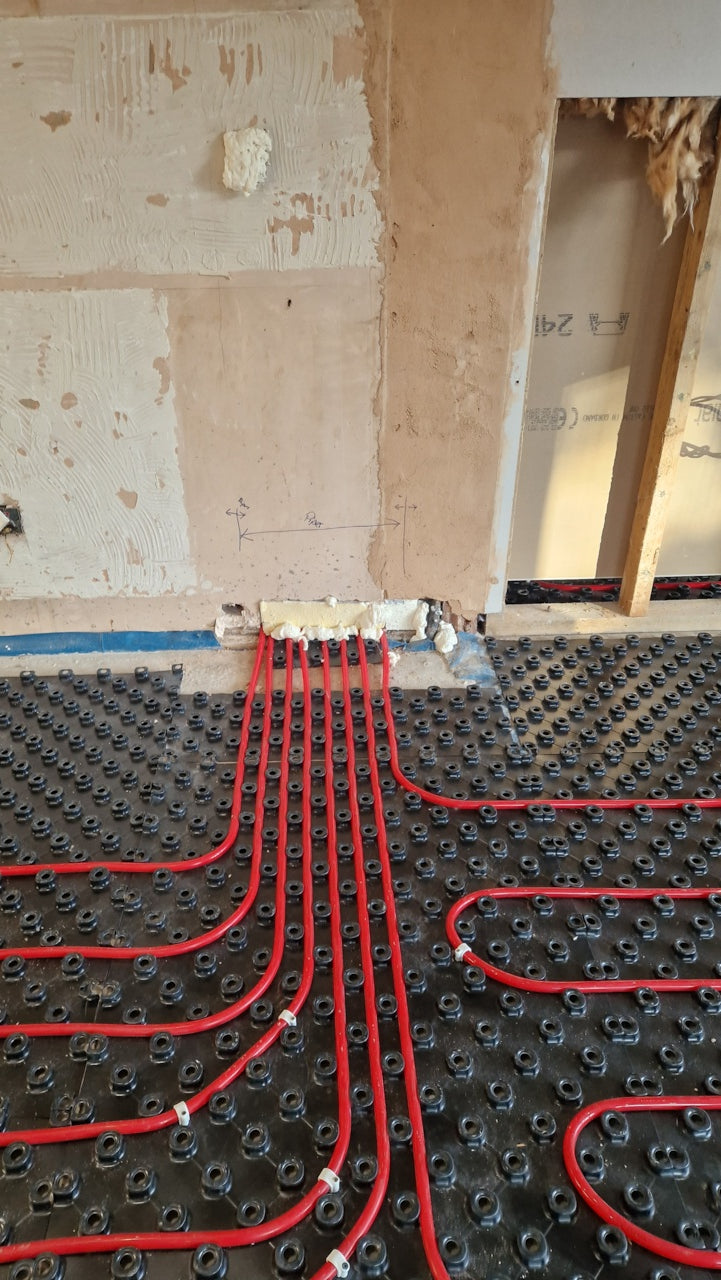 AD-TRAY heating pipe circuits routed neatly through a wall opening over castellated trays