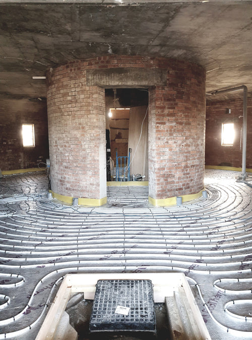 Underfloor heating installed around the water tower's central brick core
